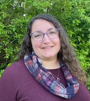 Anna Protano-Biggs headshot with a woodsy background